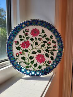 a decorative plate sitting on top of a window sill