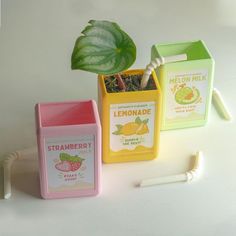 three different types of toothbrushes next to a box with lemonade and strawberries on it