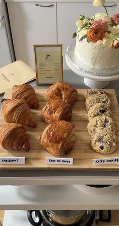 there are many different types of baked goods on the counter top, including croissants and cookies