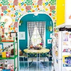 a brightly colored kitchen with colorful wallpaper and decor on the walls, including a small dining table