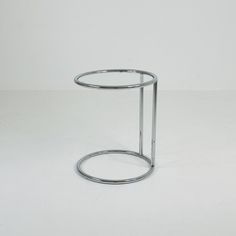 a small round metal table on a white surface with an empty space in the middle