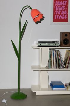 a lamp that is on top of a book shelf next to a bookshelf