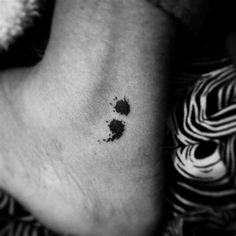 a black and white photo of a person's foot with ink splattered on it