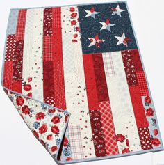 an american flag quilted placemat and pot holder on a white surface with red, white, and blue flowers