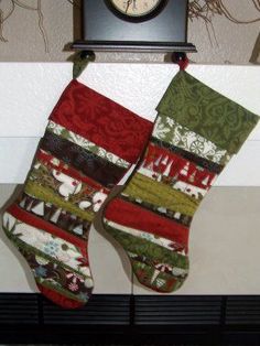 two christmas stockings hanging from a mantle with a clock