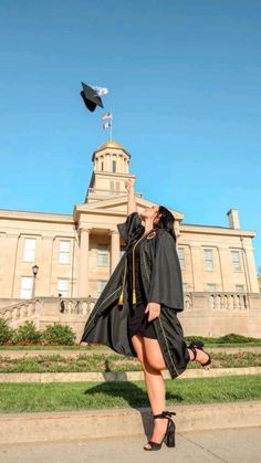 a woman in her graduation gown throwing a mortare into the air