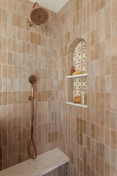 a shower head and shelf in a tiled bathroom