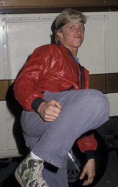 a man in red jacket sitting on top of a skateboard