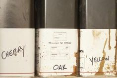 three cans with writing on them sitting on a shelf