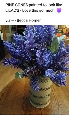 a vase filled with purple flowers on top of a wooden table