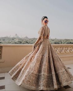 a woman in a long dress standing on a balcony