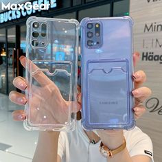 a woman holding up two samsung phones in front of her face and the case is clear