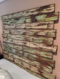 a wooden headboard made out of old wood planks in a room with a white bed