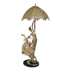 a lamp that is sitting on top of a stand with an umbrella over it's head