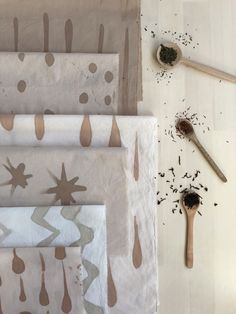 several different types of cloths and spoons on a table with paintbrushes