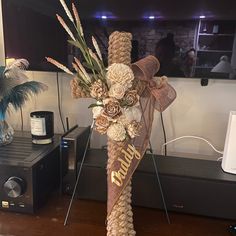 a cross made out of rope and flowers on a table next to a stereo system