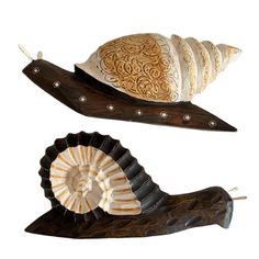 two decorative items are sitting on top of each other, one snail and the other shell