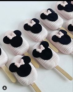 mickey mouse cupcakes are arranged in rows on wooden skewers with white and black icing