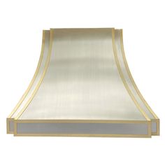 a gold and silver range hood on a white background with the light reflecting off it's side