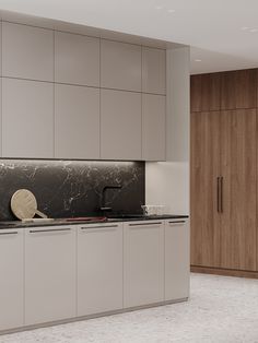 a kitchen with white cabinets and marble counter tops