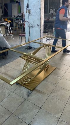 a large metal object sitting on top of a tile floor next to a man in a blue shirt