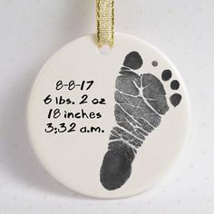 a ceramic ornament with a baby's footprints and date printed on it