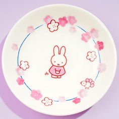 a plate with an image of a rabbit on it and pink flowers around the edge