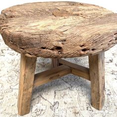 a wooden stool made out of logs on top of a rug