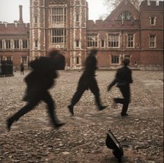 blurry photograph of people running in front of a building