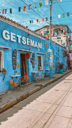 a blue building with lots of colorful flags hanging from it's sides