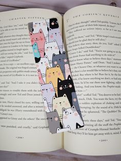 an open book with cats on it and the pages are lined up in different colors