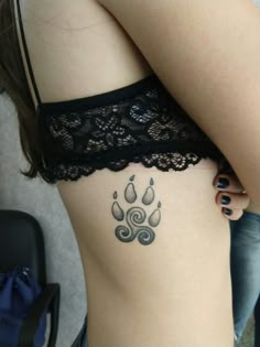 a woman's stomach with a tattoo on it that looks like a dog paw