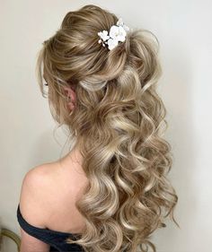 a woman with long blonde hair and flowers in her hair is shown from the back