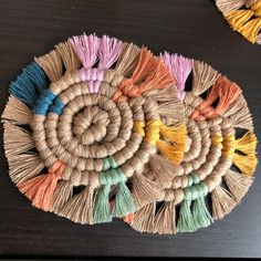 several different colored tassels are arranged on a black table with two other tassels in the background