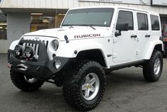 a white jeep parked in front of a building