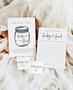 two wedding guest cards sitting on top of a bed next to an envelope and pen