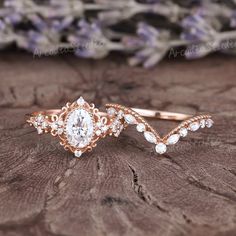 a close up of a ring on top of a piece of wood with flowers in the background