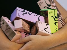 a woman's hands holding several boxes of chocolate