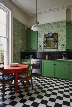 a kitchen with green cabinets and black and white checkered flooring on the walls