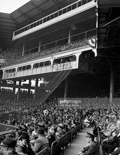 an old black and white photo of people sitting in the stands at a baseball game