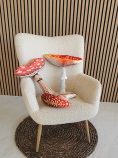 a white chair with red polka dots on it and a mushroom shaped footstool