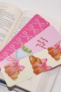 an open book with some stickers on top of it next to a cupcake