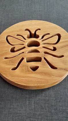 a wooden plate with a carved bee on it