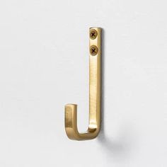 an image of a door handle on a white wall with the letter j in gold