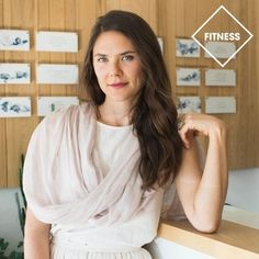 a woman standing in front of a wall with business cards on it