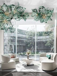 a living room filled with lots of furniture and large glass windows that look out onto a courtyard