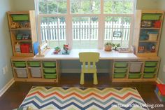 a child's playroom with toys and bookshelves in the window sill