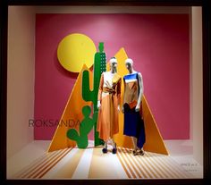 two mannequins are standing in front of a colorful wall with cactuses