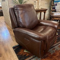 a brown recliner chair sitting on top of a wooden floor