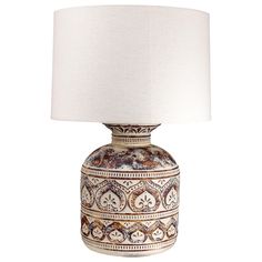 an ornate ceramic lamp with a white shade on it's base and a beige linen lampshade